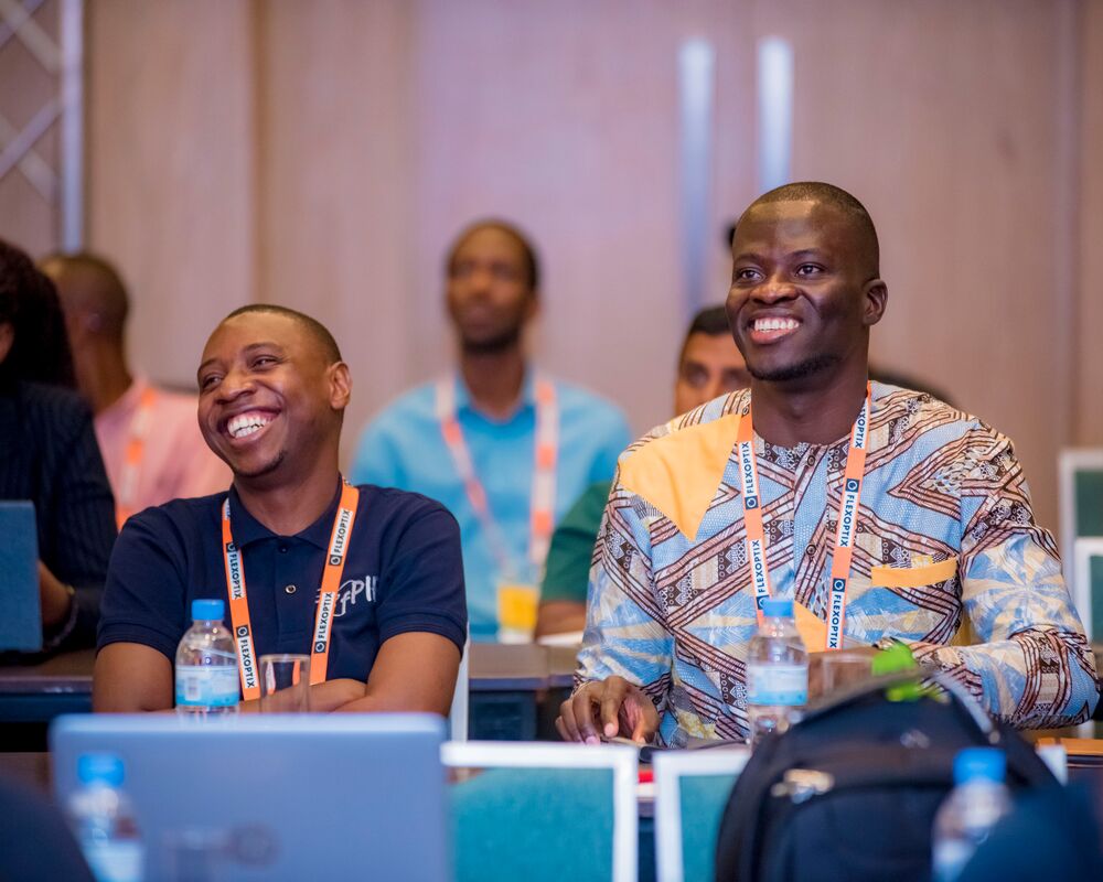 two men sitting and smiling