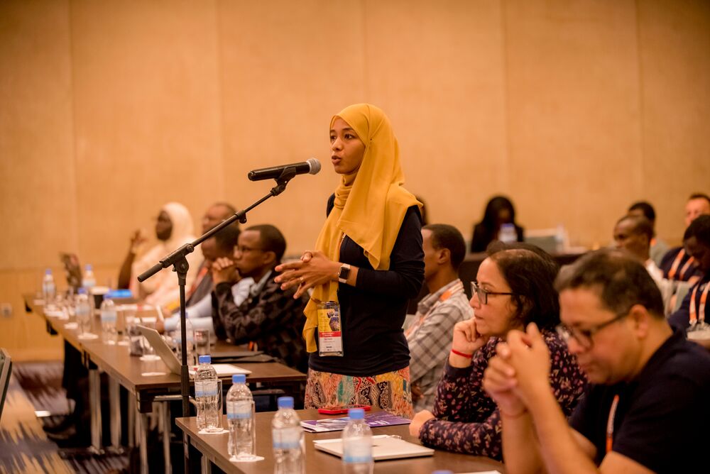 a woman asking a question at open mic session